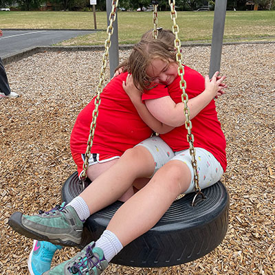 two friends on a tire swing